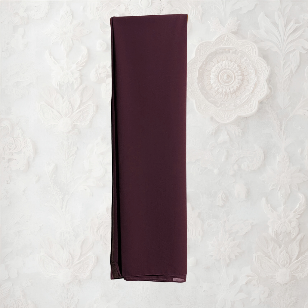Brown clothing rack with a coffee fabric draped over it against a white wall.