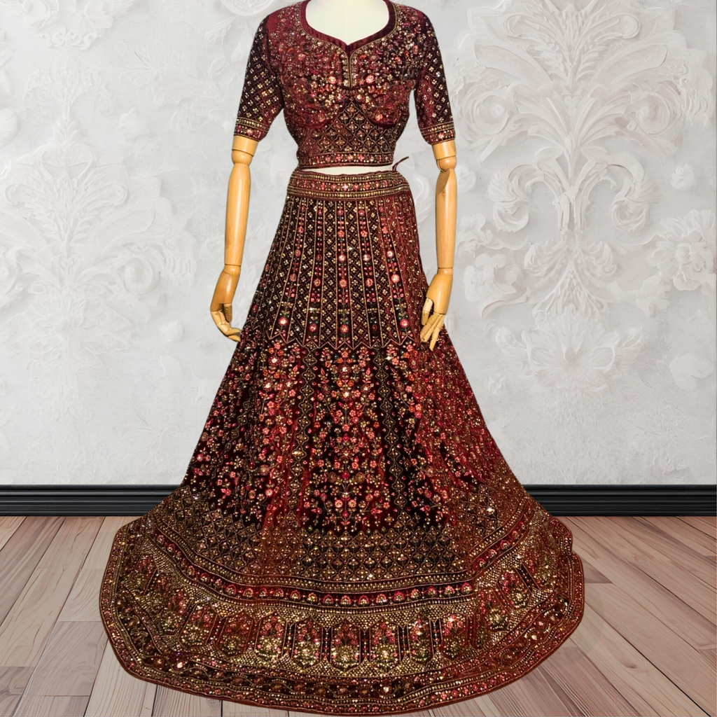 Maroon Lehenga with gold embroidery on a mannequin against a white wall. traditional desi, Indian, Pakistani, Bangladeshi, Sri lankan bridal ware for wedding. 