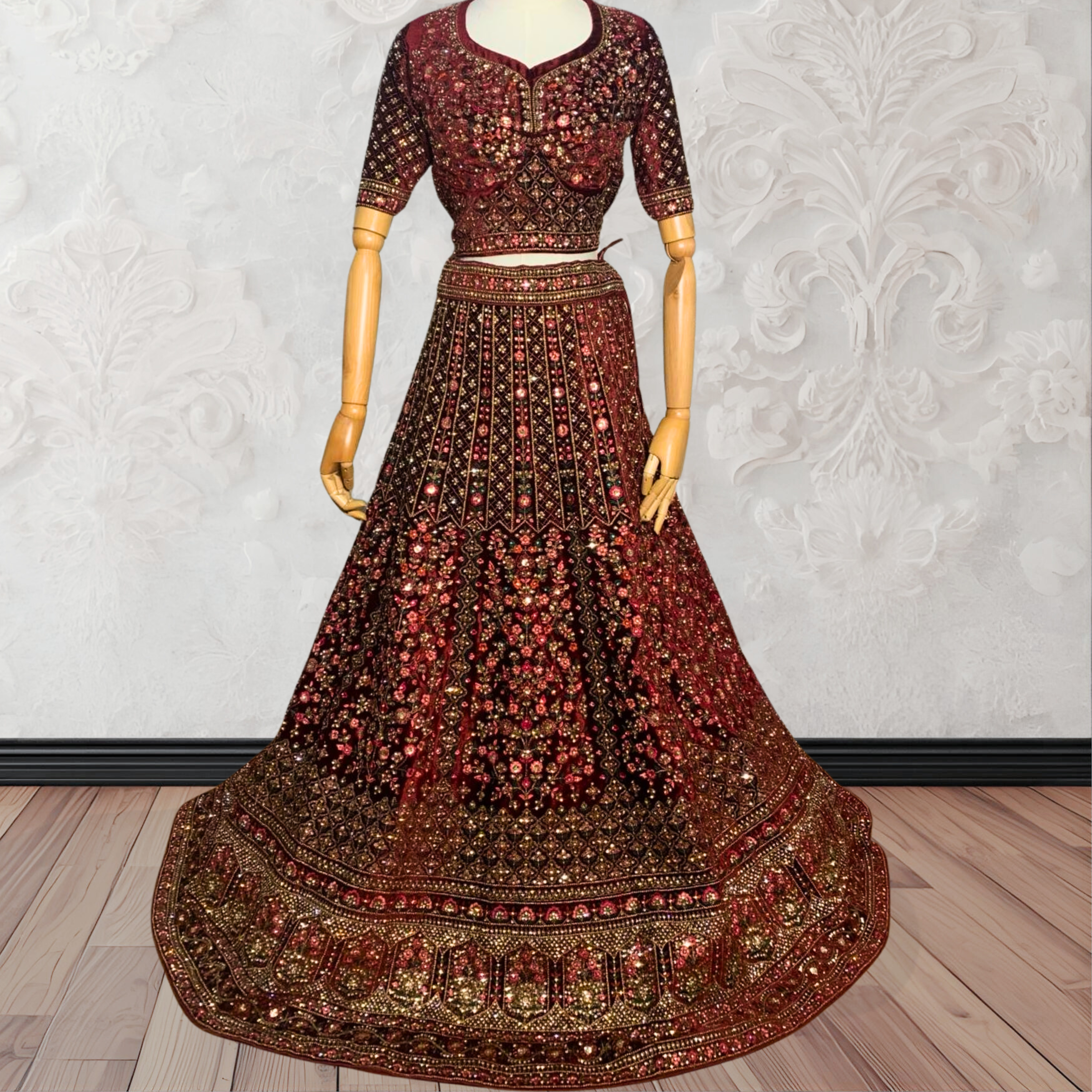 Maroon Lehenga with gold embroidery on a mannequin against a white wall. traditional desi, Indian, Pakistani, Bangladeshi, Sri lankan bridal ware for wedding. 