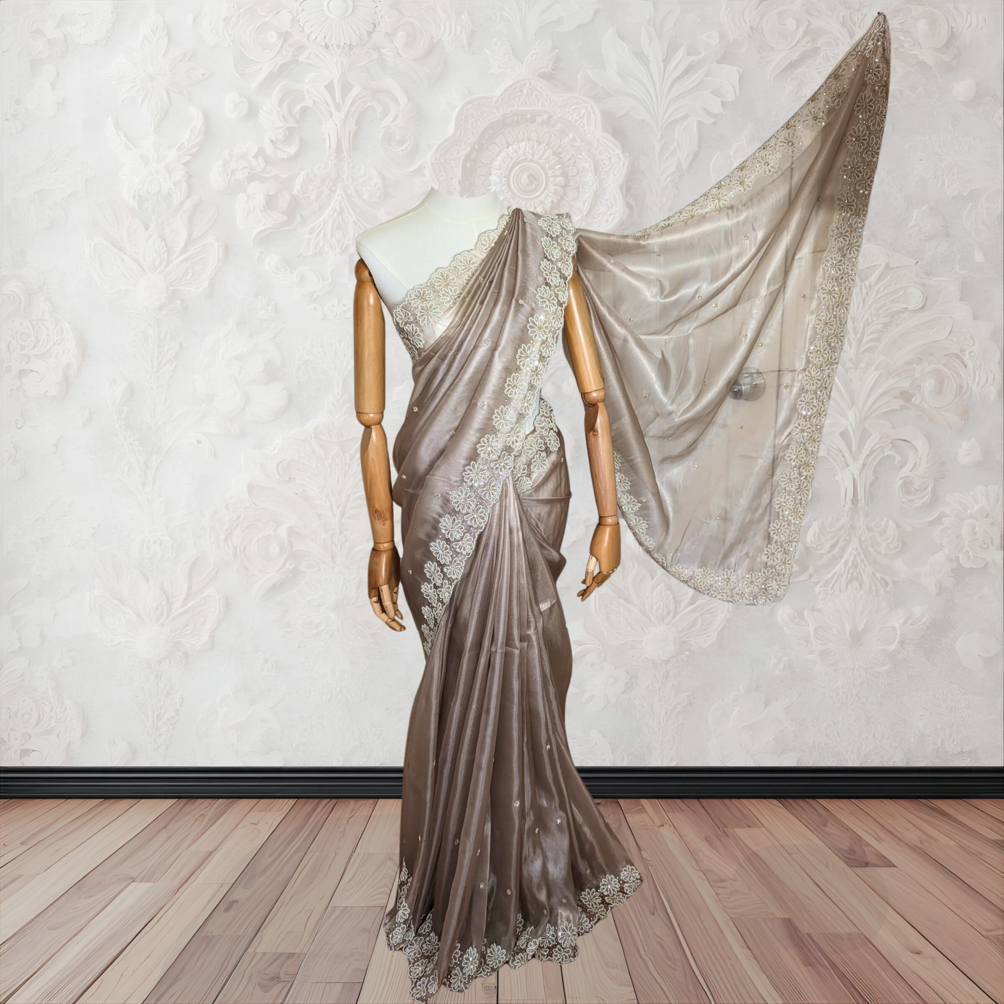 Saree with a mannequin against a decorative wall.