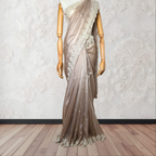 Mannequin wearing a beige saree with lace details on a wooden floor and white wall background