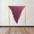 Purple fabric draped over a yellow garment rack against a white wall.