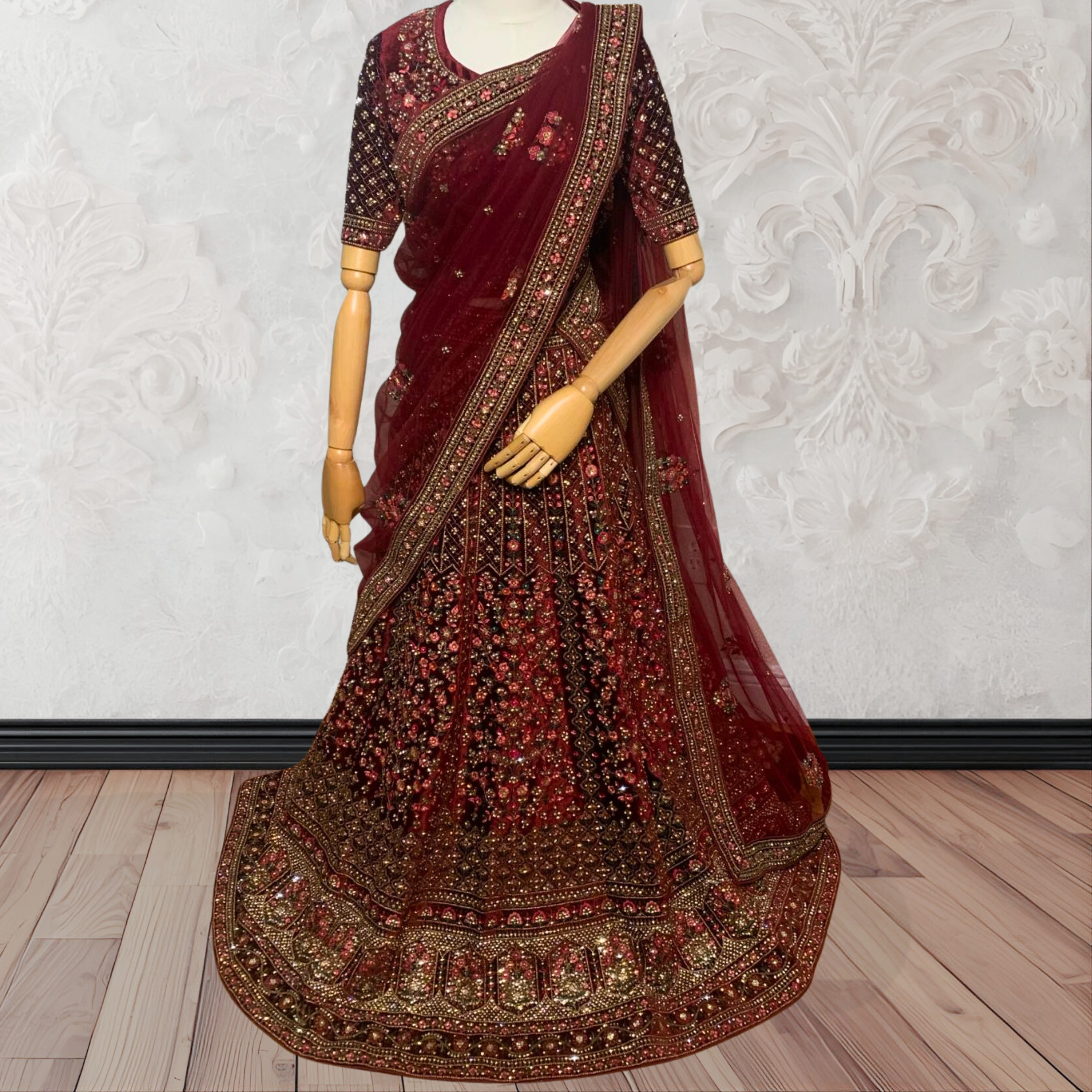 Maroon Lehenga with gold embroidery on a mannequin against a white wall. traditional desi, Indian, Pakistani, Bangladeshi, Sri lankan bridal ware for wedding. 