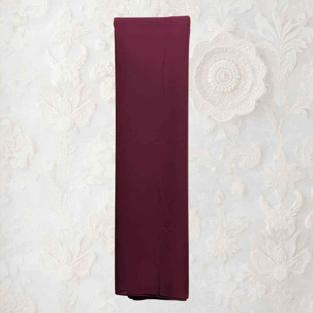 coffee color fabric draped over a yellow garment rack against a white wall. fabric on a textured white background