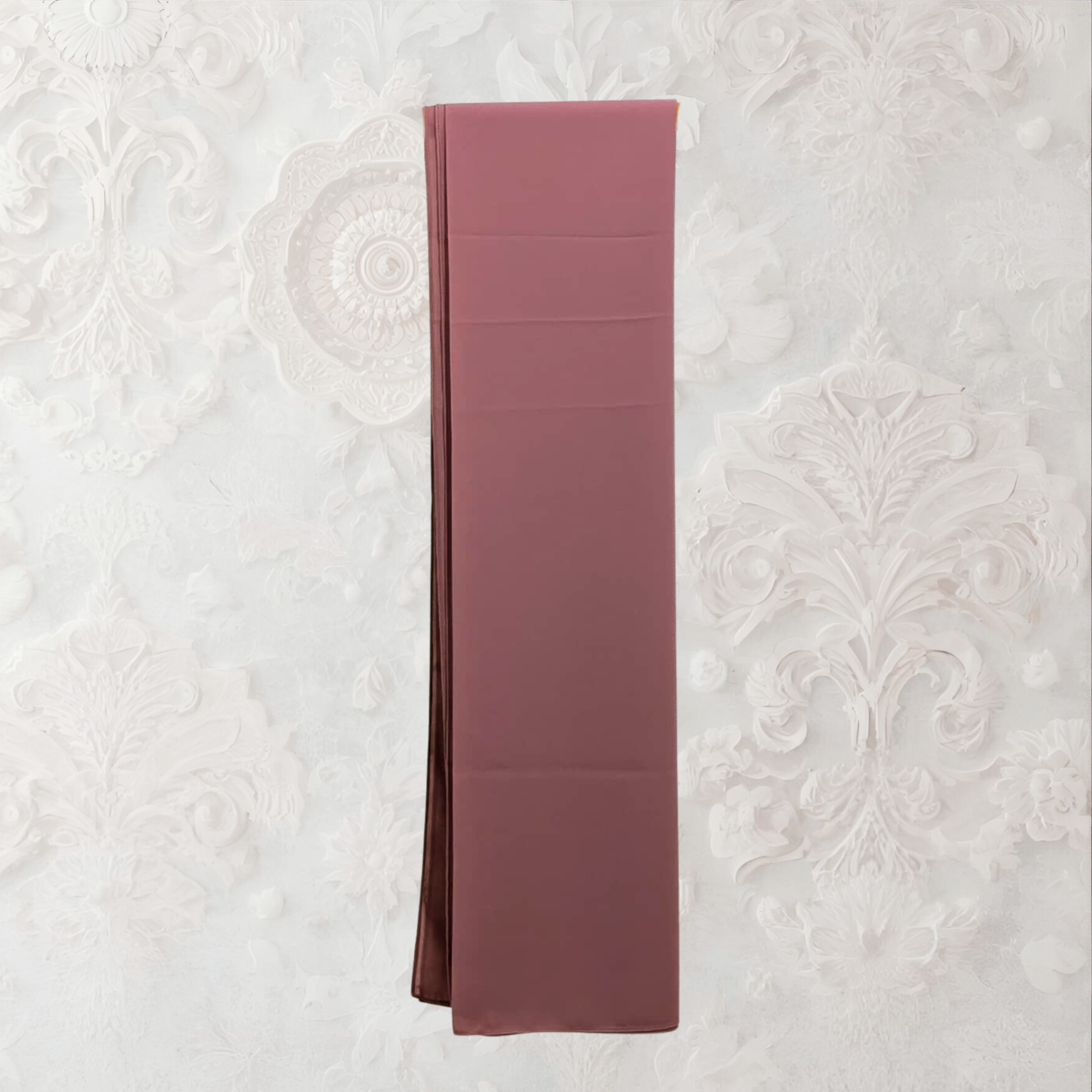 Folded pink fabric on a textured white background chiffon hijab