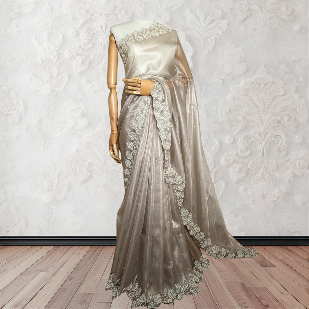 Saree with lace detailing on a mannequin against a white wall.
