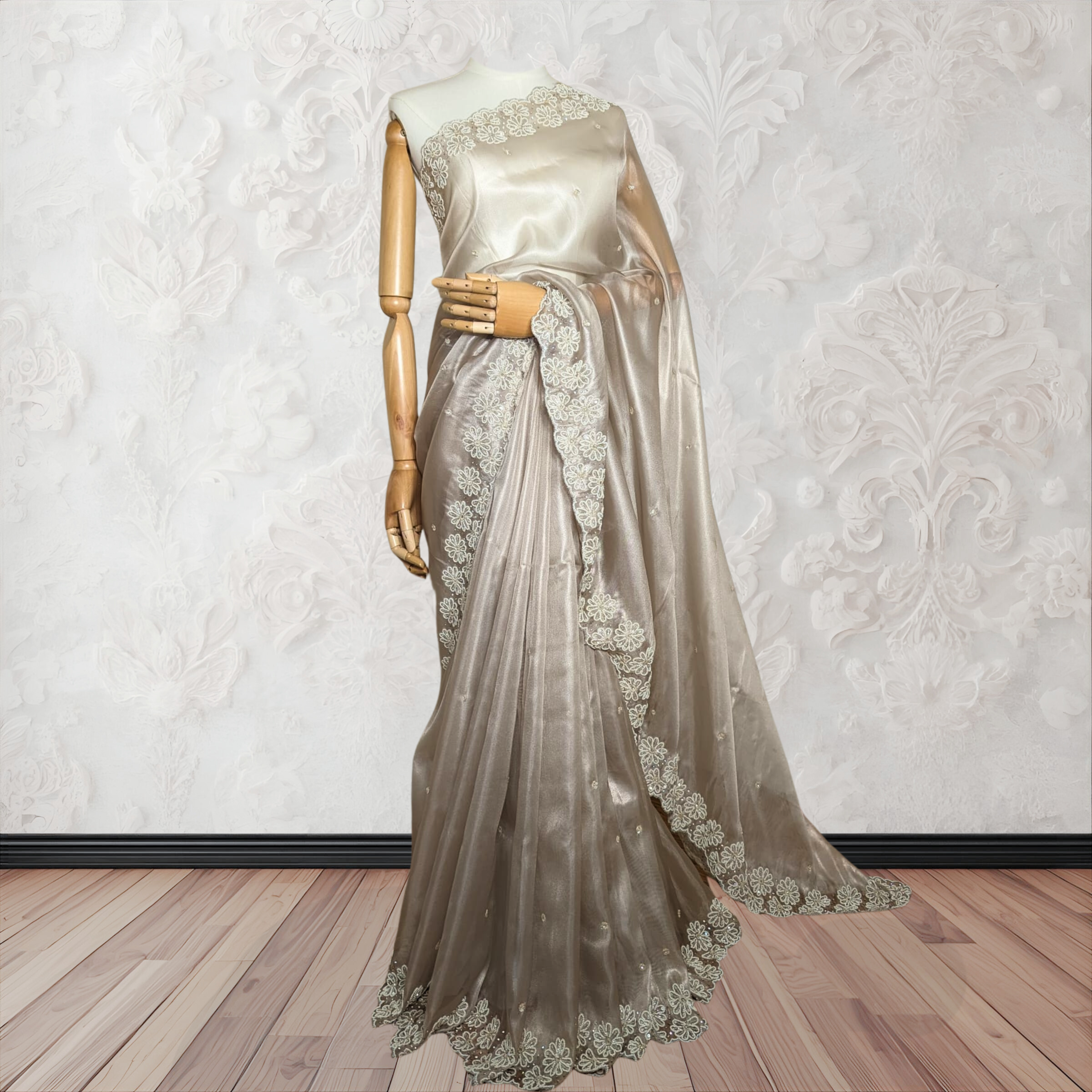 Saree with lace detailing on a mannequin against a white wall.