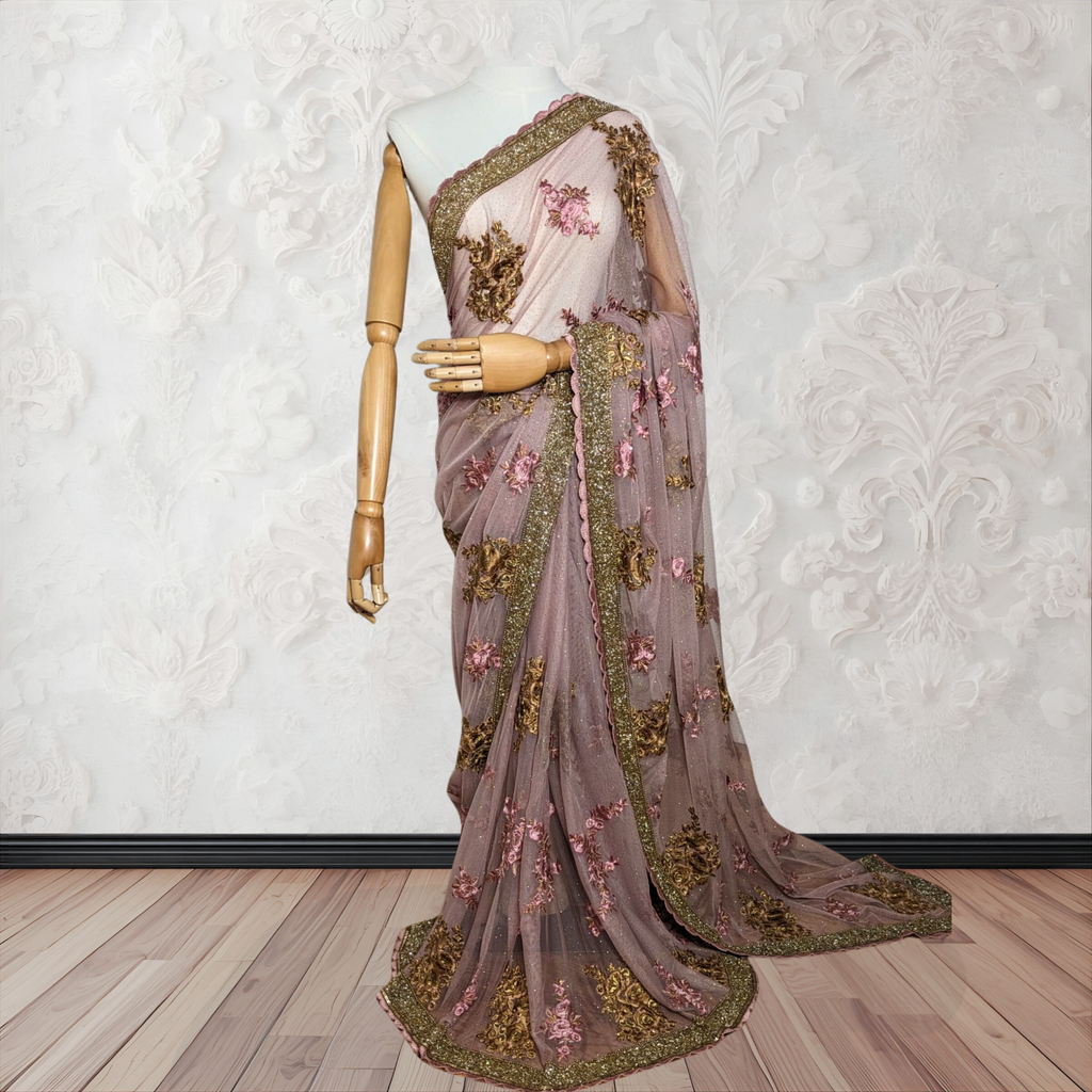 Decorative saree with floral and gold embroidery on a mannequin against a white wall.