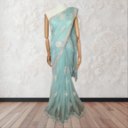 Light blue saree with white floral embroidery on a mannequin against a white wall.