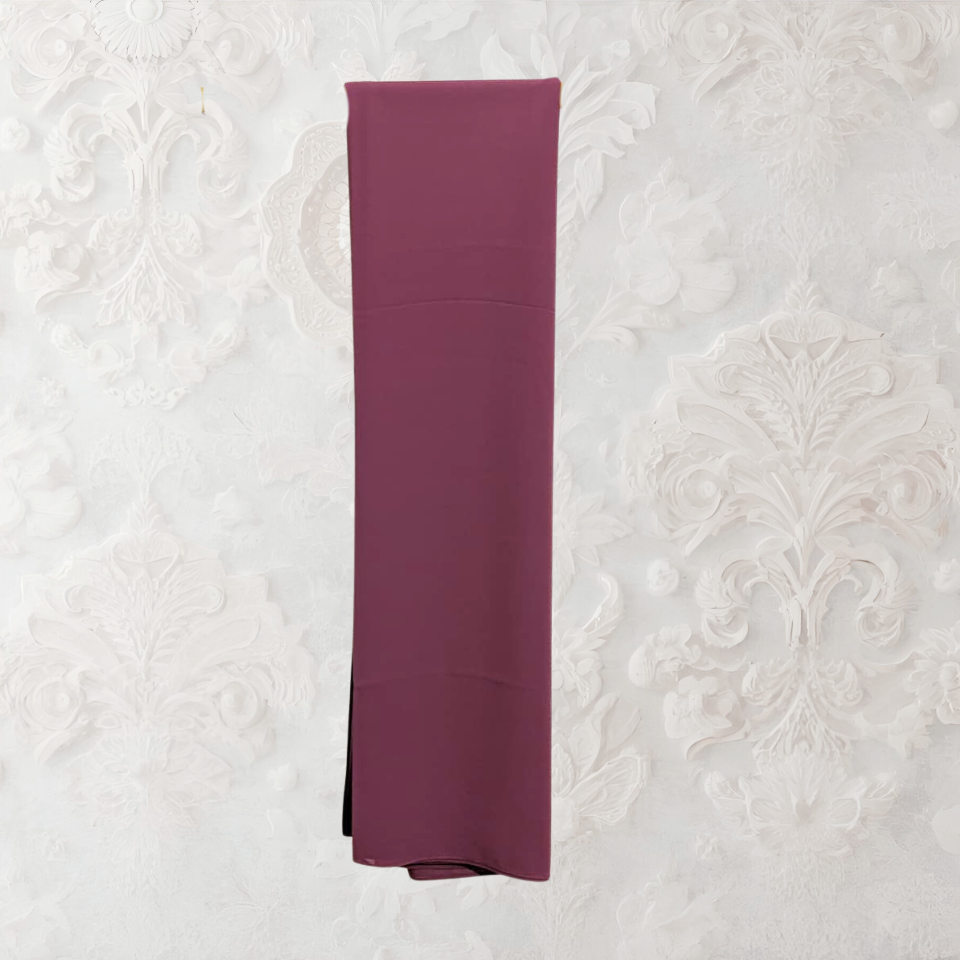 Folded purple fabric on a textured white background