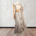 Mannequin wearing a beige saree with floral lace details against a decorative wall.