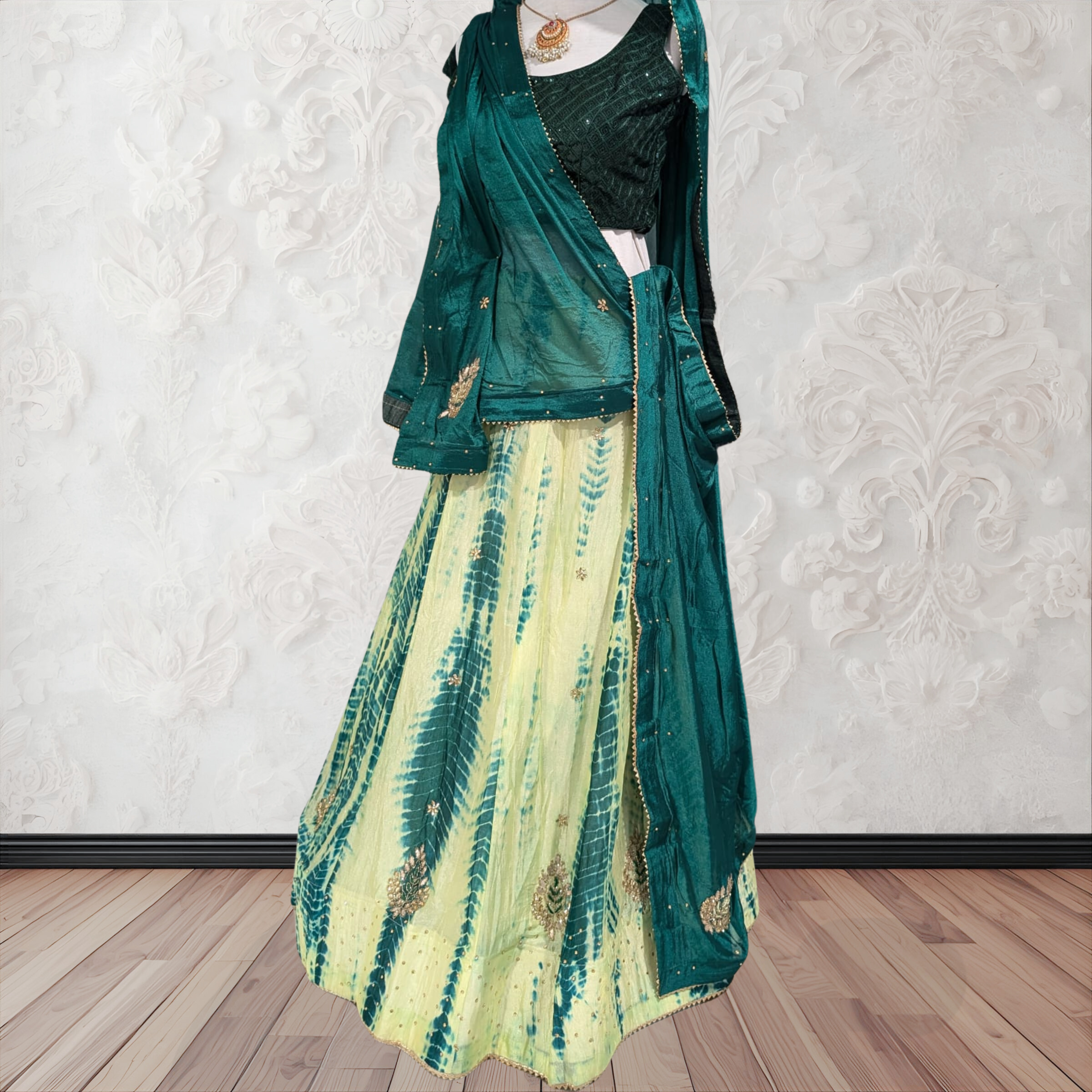 Green and yellow dress with matching jacket on a mannequin against a white wall.