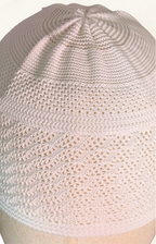 Knitted cap on a mannequin head against a white background