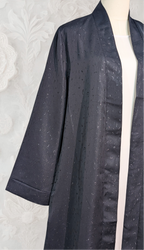 Dark gray textured robe on a mannequin against a white textured background