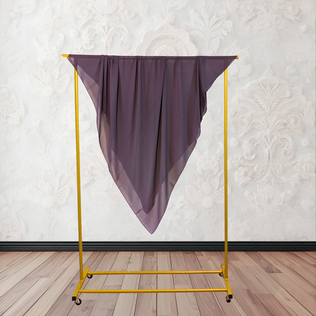 Purple fabric draped over a yellow garment rack against a white wall.