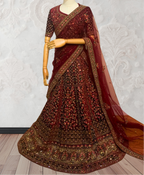 Maroon embroidered traditional outfit on a mannequin against a white textured wall.