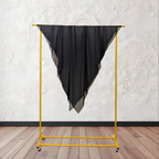 Black fabric on a yellow garment rack against a white wall.