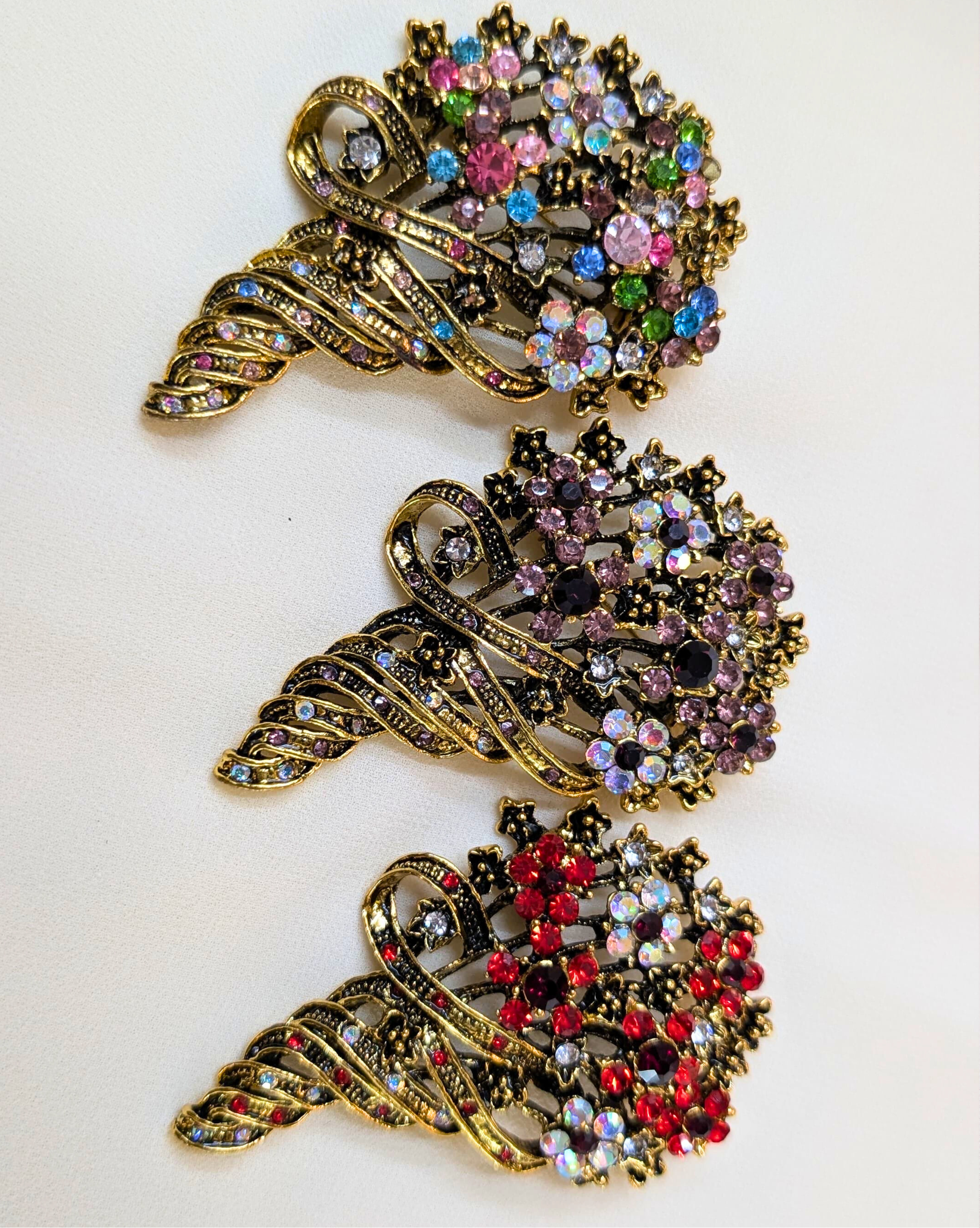 Decorative brooches with colorful gemstones on a white background
