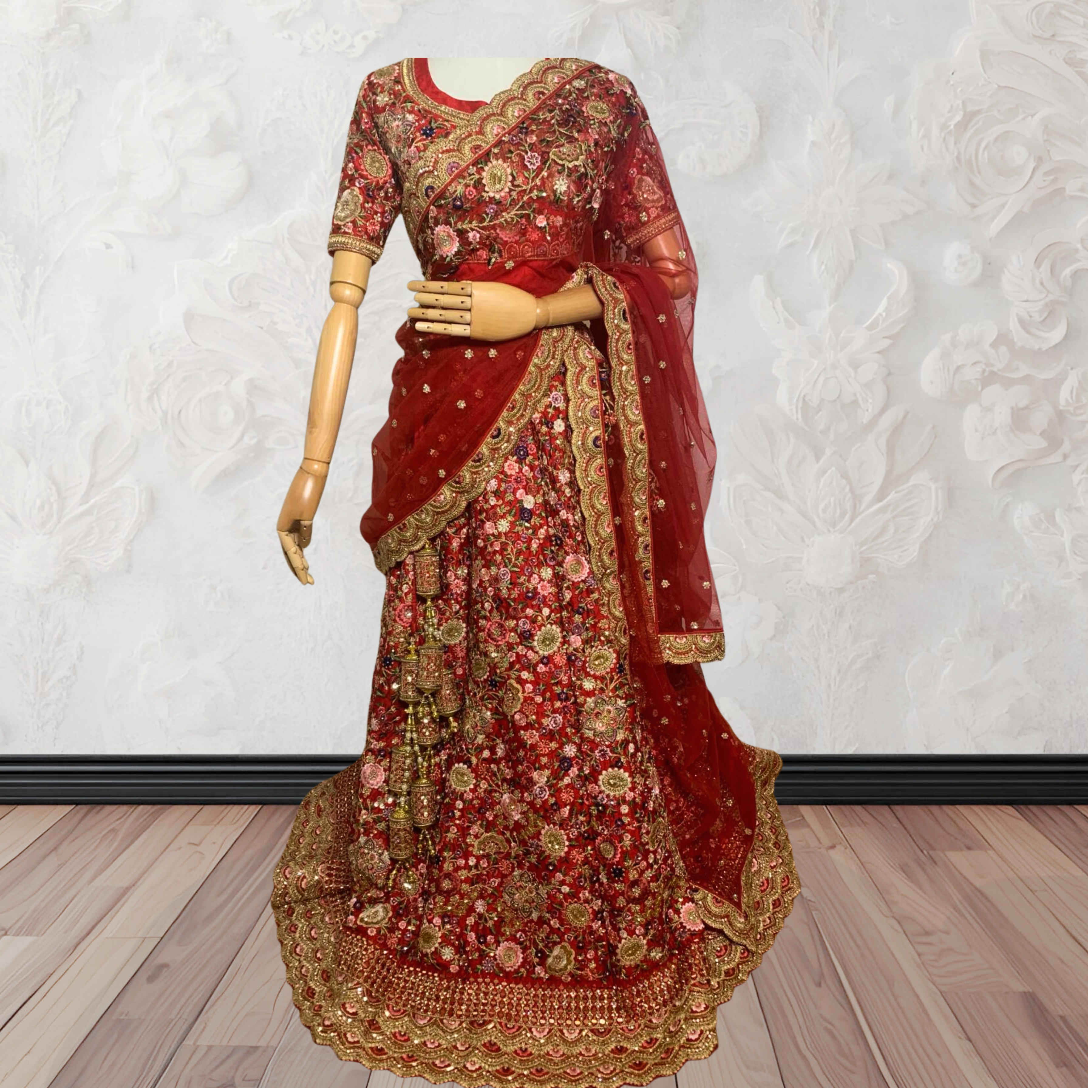 This exquisite red lehenga choli crafted from luxurious raw silk showcases intricate resham, zardosi, beads, sequins, and cut dana floral embroidery. The heavily embellished hemline and delicate cream butti accents enhance its sophisticated charm. Complete with a matching embroidered net dupatta featuring floral buttis and an elegant border, and a stitched blouse piece adorned with coordinating floral motifs, for wedding and bridal, pakistani, bangladeshi, indian, sri lankan.