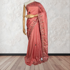 Pink saree with intricate designs on a mannequin against a white wall.