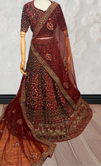Maroon Lehenga with gold embroidery on a mannequin against a white wall. traditional desi, Indian, Pakistani, Bangladeshi, Sri lankan bridal ware for wedding. 