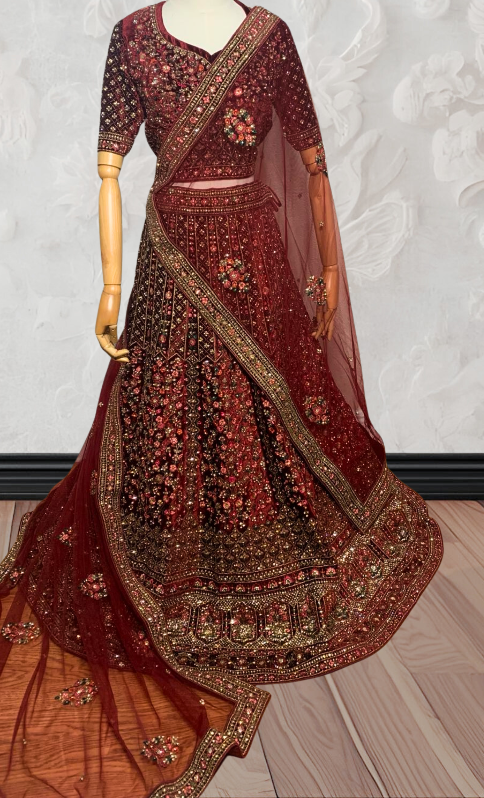 Maroon Lehenga with gold embroidery on a mannequin against a white wall. traditional desi, Indian, Pakistani, Bangladeshi, Sri lankan bridal ware for wedding. 