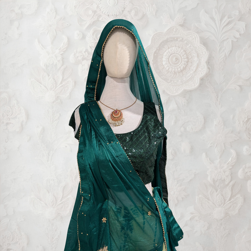 Mannequin wearing a green saree with a matching dupatta against a textured white background