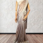 Mannequin wearing a beige saree with lace details against a white wall.