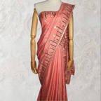Coral saree with black embroidery on a mannequin against a white background