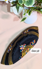 Decorative black patch with colorful embroidery on a light pink background