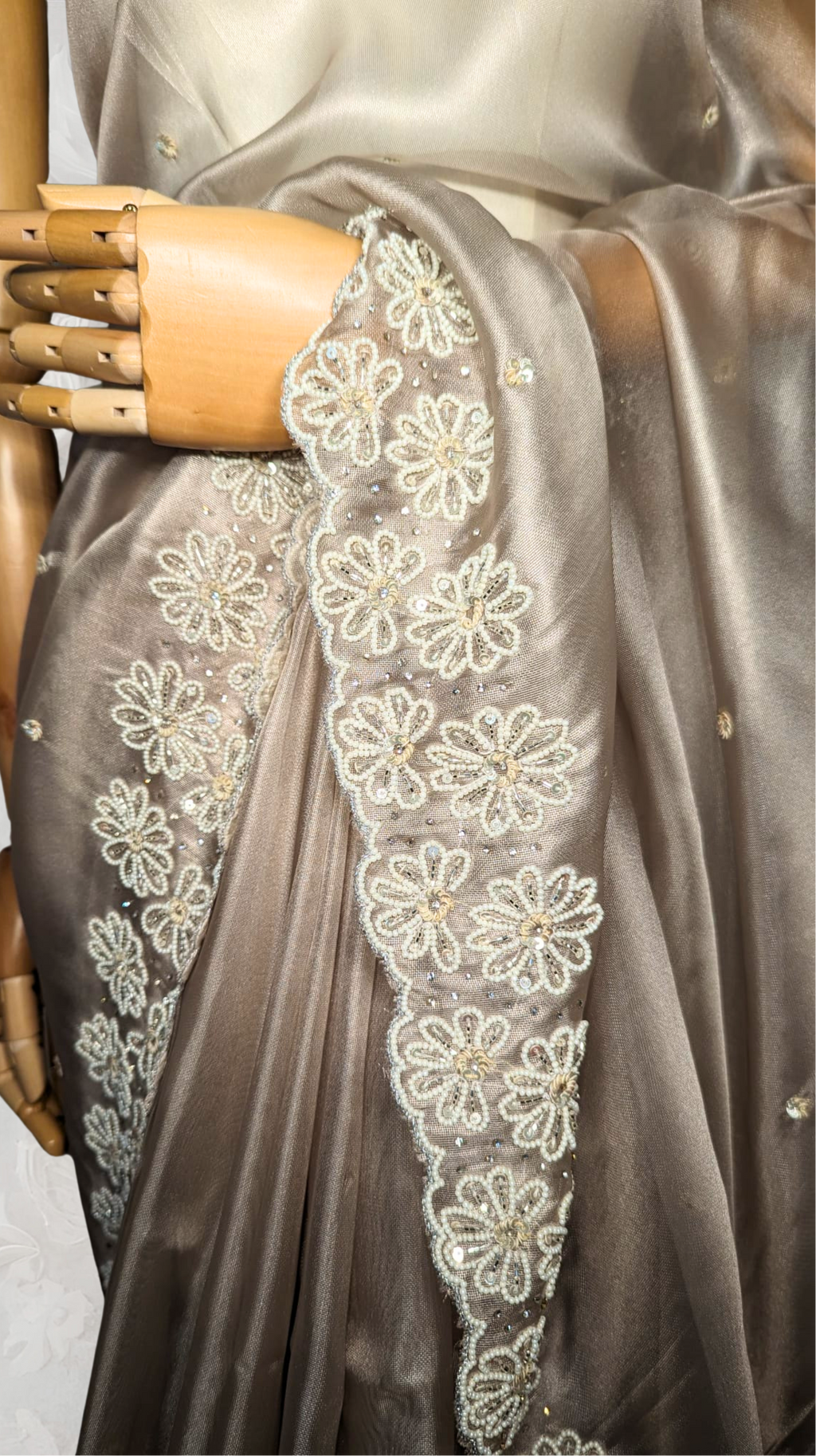 Gray saree with floral lace border on a textured white background